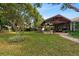 Manicured backyard with a covered patio featuring a brick fireplace and well-maintained landscaping, perfect for outdoor enjoyment at 4508 Compass Oaks Dr, Valrico, FL 33596