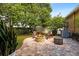 Cozy backyard patio with a stone fire pit, comfortable chairs, and lush greenery for a relaxing outdoor experience at 4508 Compass Oaks Dr, Valrico, FL 33596