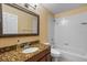 A clean bathroom features a granite countertop, a framed mirror, and a shower-tub combo at 4508 Compass Oaks Dr, Valrico, FL 33596