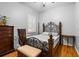 Cozy bedroom featuring hardwood floors, a decorative metal bed frame, and ample natural light at 4508 Compass Oaks Dr, Valrico, FL 33596