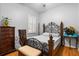Cozy bedroom featuring hardwood floors, a decorative metal bed frame, and ample natural light at 4508 Compass Oaks Dr, Valrico, FL 33596