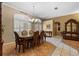 An elegant dining room features decorative flooring, chandelier, and large windows with wooden shutters at 4508 Compass Oaks Dr, Valrico, FL 33596