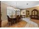 An elegant dining room features decorative flooring, chandelier, and large windows with wooden shutters at 4508 Compass Oaks Dr, Valrico, FL 33596