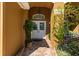 Elegant entryway features decorative glass doors, brick flooring, and lush landscaping at 4508 Compass Oaks Dr, Valrico, FL 33596