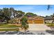 Charming home featuring a two-car garage, manicured lawn, mature trees, and solar panels at 4508 Compass Oaks Dr, Valrico, FL 33596