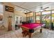 Bright, enclosed game room showcasing a billiards table, comfortable seating, and natural light at 4508 Compass Oaks Dr, Valrico, FL 33596