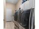 A functional laundry room boasts modern machines, storage cabinets, and tiled floors at 4508 Compass Oaks Dr, Valrico, FL 33596