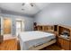 This light filled main bedroom features hard wood floors, large bed, and ensuite bathroom entrance at 4508 Compass Oaks Dr, Valrico, FL 33596