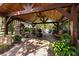 Covered outdoor living space featuring a stone fireplace, ample seating, and lush landscaping at 4508 Compass Oaks Dr, Valrico, FL 33596
