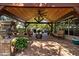Spacious covered patio featuring a brick fireplace, ceiling fans, and comfortable seating for outdoor relaxation at 4508 Compass Oaks Dr, Valrico, FL 33596