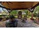 Comfortable outdoor patio featuring a brick fireplace, ceiling fans, and cozy seating for relaxing in the backyard at 4508 Compass Oaks Dr, Valrico, FL 33596