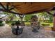 Inviting outdoor patio area with a brick fireplace, ceiling fan, and cozy seating perfect for entertaining guests at 4508 Compass Oaks Dr, Valrico, FL 33596