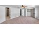 Spacious bedroom with ceiling fan, large closet, en suite bathroom, and neutral carpet at 4733 W Vasconia St, Tampa, FL 33629