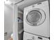 Laundry room featuring a stacked Samsung washer and dryer and floating shelves at 4733 W Vasconia St, Tampa, FL 33629