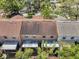 Back view of townhomes with screened-in patios and a view of mature trees, creating a private outdoor space at 4733 W Vasconia St, Tampa, FL 33629