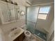 Full bathroom needing repairs featuring a sink, toilet, shower with glass doors, and window at 4911 Largo Ter, New Port Richey, FL 34652