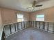 Bedroom with two windows, ceiling fan, and damaged walls, showcasing the property's potential for renovation at 4911 Largo Ter, New Port Richey, FL 34652