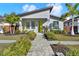 Charming single Gathering home with a well-manicured lawn, walkway, and a bright yellow front door at 511 45Th N Ave, St Petersburg, FL 33703