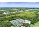 Community aerial view featuring tennis courts, a swimming pool, and surrounding wooded areas at 5115 Tobermory Way, Bradenton, FL 34211
