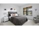 A stylish bedroom with a plush bed, modern nightstands, contemporary artwork, and a large window for natural light at 5115 Tobermory Way, Bradenton, FL 34211