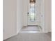 The foyer features tile flooring transitioning to carpet, with a decorative glass front door and neutral-toned walls at 5115 Tobermory Way, Bradenton, FL 34211