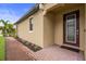 The front entrance features a brick walkway and a glass-paneled front door flanked by a window and green landscaping at 5115 Tobermory Way, Bradenton, FL 34211