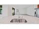 Kitchen island sink with granite counters and a view of the modern open floorplan at 5115 Tobermory Way, Bradenton, FL 34211