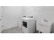 Bright laundry room featuring a washing machine, dryer, utility sink, and wire shelving at 5115 Tobermory Way, Bradenton, FL 34211