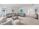 A bright living room with neutral furniture, modern artwork, and neutral walls and carpeting at 5115 Tobermory Way, Bradenton, FL 34211