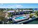 Aerial view of waterfront condos featuring a pool, lounge chairs, palm trees, and stunning bay views at 525 Bahia Beach Blvd, Ruskin, FL 33570