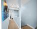 This hallway has carpet flooring and neutral blue walls with artwork at 525 Bahia Beach Blvd, Ruskin, FL 33570