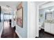 Hallway leading to the bathroom, featuring wall art and a view of the adjacent living area at 525 Bahia Beach Blvd, Ruskin, FL 33570