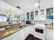 Bright kitchen with granite countertops, white cabinets, and an open layout to the dining area at 525 Bahia Beach Blvd, Ruskin, FL 33570