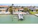 Aerial view of waterfront home, pool, boat dock, and lush landscaping on a sunny day at 571 Johns Pass Ave, Madeira Beach, FL 33708
