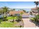 Charming home with a well-manicured lawn, palm trees, and a convenient two-car garage at 571 Johns Pass Ave, Madeira Beach, FL 33708