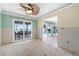 Living room with ceiling fan and view of covered deck with dining set and water at 571 Johns Pass Ave, Madeira Beach, FL 33708