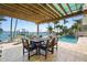 Waterfront outdoor dining with a pergola, a boat lift, and a swimming pool, perfect for entertaining guests at 571 Johns Pass Ave, Madeira Beach, FL 33708