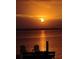 Stunning sunset view with Adirondack chairs by the water, perfect for relaxing and enjoying the tranquil scenery at 571 Johns Pass Ave, Madeira Beach, FL 33708