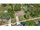 Aerial view showcasing the property and its surrounding landscape, including lush trees and nearby pools at 5905 Caroline Dr, Wesley Chapel, FL 33545