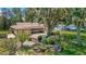 Spacious backyard featuring lush greenery, a brick patio, and mature trees, creating a private outdoor space at 5905 Caroline Dr, Wesley Chapel, FL 33545