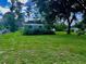 Large grassy backyard featuring an outbuilding at 5905 Caroline Dr, Wesley Chapel, FL 33545