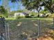 Backyard featuring a chain-link fence, shed, grass, and mature trees at 5905 Caroline Dr, Wesley Chapel, FL 33545
