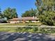Charming single-story home with a well-maintained lawn and mature trees at 5905 Caroline Dr, Wesley Chapel, FL 33545