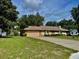 Spacious driveway leads to a home with a well-maintained lawn and mature landscaping at 5905 Caroline Dr, Wesley Chapel, FL 33545