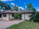 Single-story home with a side entrance and a brick-paved walkway and lush landscaping at 5905 Caroline Dr, Wesley Chapel, FL 33545