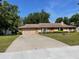 Spacious driveway leads to a home with a well-maintained lawn and mature landscaping at 5905 Caroline Dr, Wesley Chapel, FL 33545
