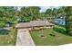 Charming single-story home featuring a well-manicured lawn, a long driveway, and an attached garage at 5905 Caroline Dr, Wesley Chapel, FL 33545