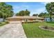 Well-maintained single-Gathering home with a spacious front lawn, a long driveway, and attached garage at 5905 Caroline Dr, Wesley Chapel, FL 33545