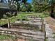 View of the garden with wooden planters, patio and greenery at 5905 Caroline Dr, Wesley Chapel, FL 33545