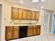 Traditional kitchen with wooden cabinets and a black dishwasher offers functionality and classic design at 5905 Caroline Dr, Wesley Chapel, FL 33545